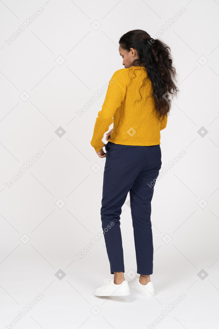 Rear view of a girl in casual clothes looking at her shirt