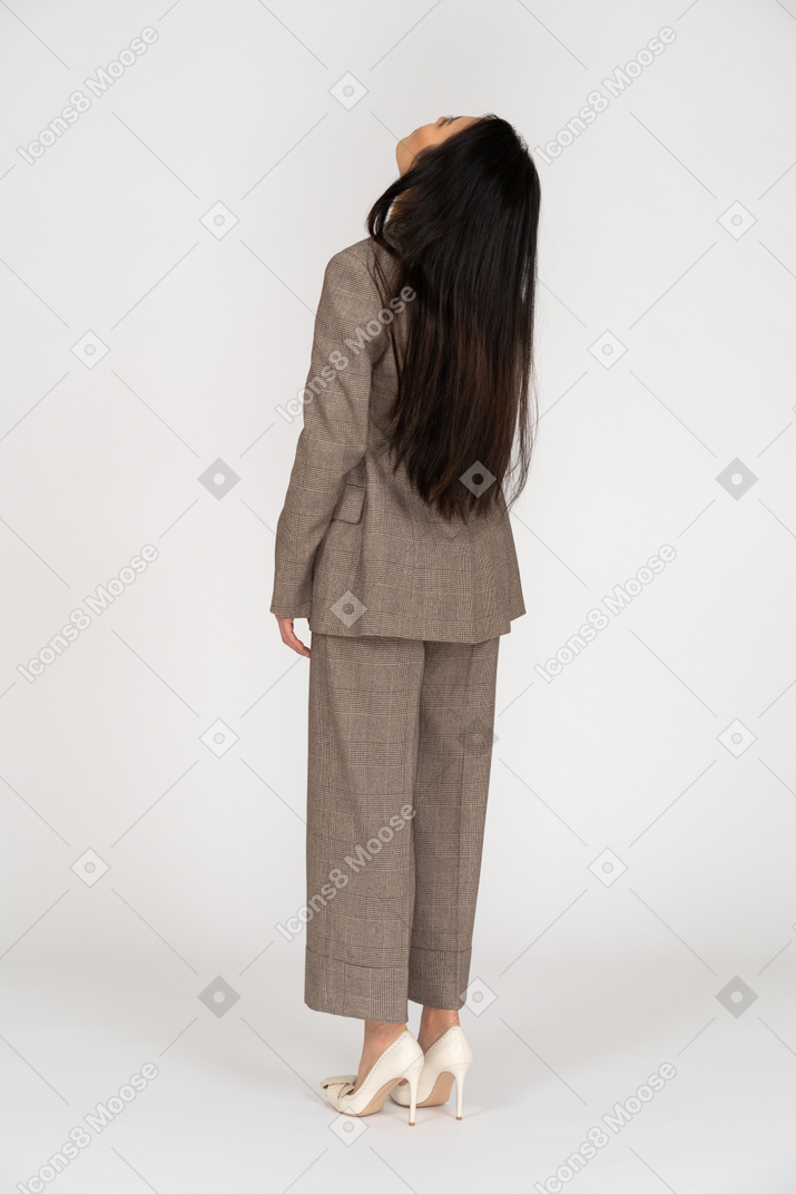 一位年轻的女士，穿着棕色西装的四分之三的背影回头