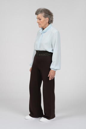 Old woman standing with eyes down