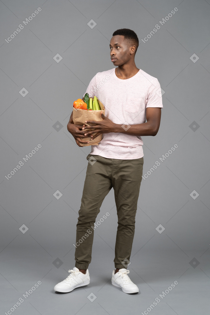 Um jovem carregando uma sacola de compras