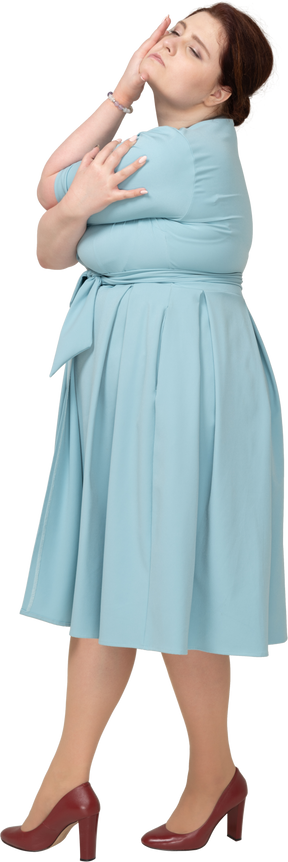 Vista laterale di una donna in abito blu in posa