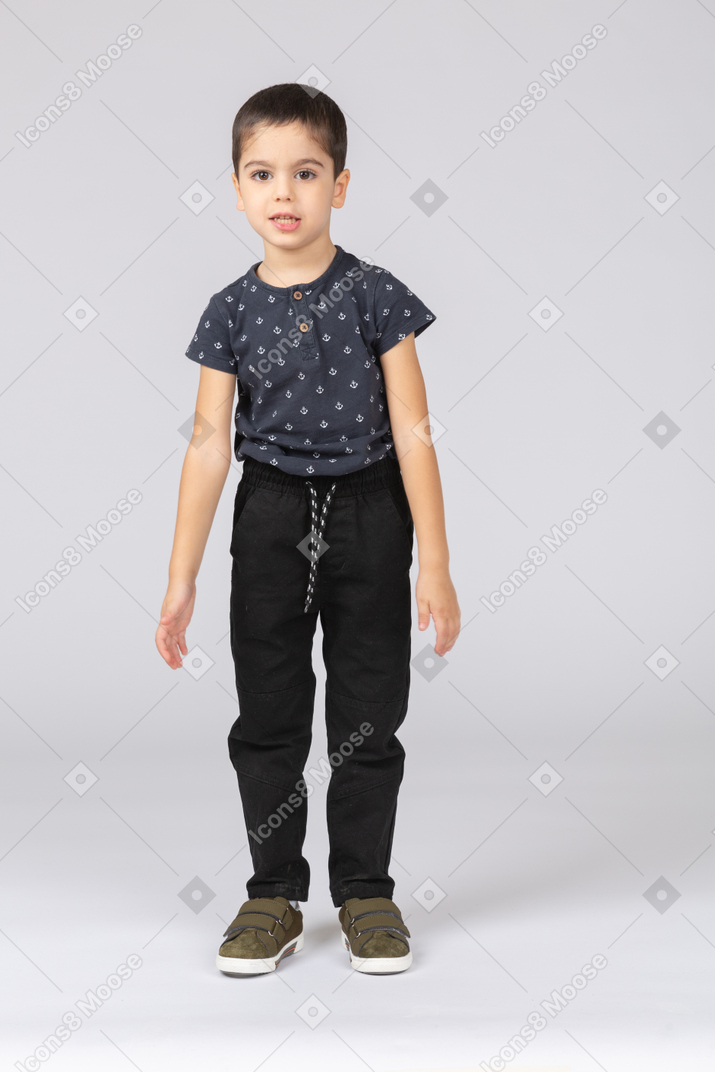 Vue de face d'un garçon mignon dans des vêtements décontractés prêt à sauter