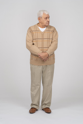 Front view of an old man in casual clothes looking aside