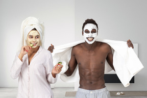 Young girl and guy with facial masks getting ready