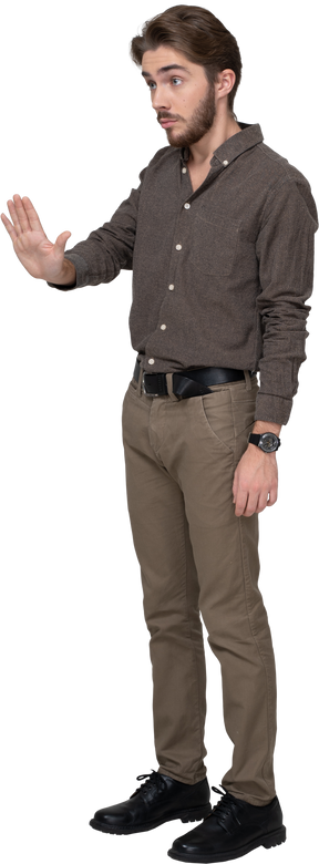 Трехчетвертный вид молодого человека в офисной одежде, протягивающего руку