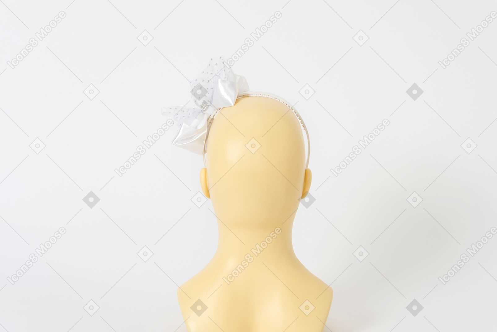 Diadema blanca con un lazo en la cabeza de un maniquí