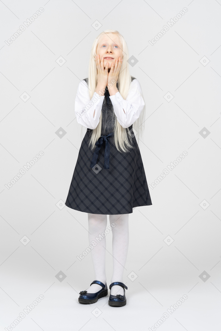 Schoolgirl holding her face and looking sad