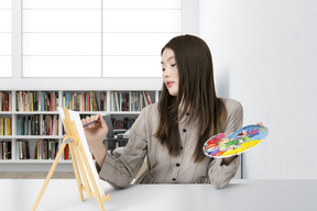 Young woman painting on a canvas
