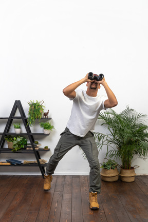 Good looking young man holding binoculars