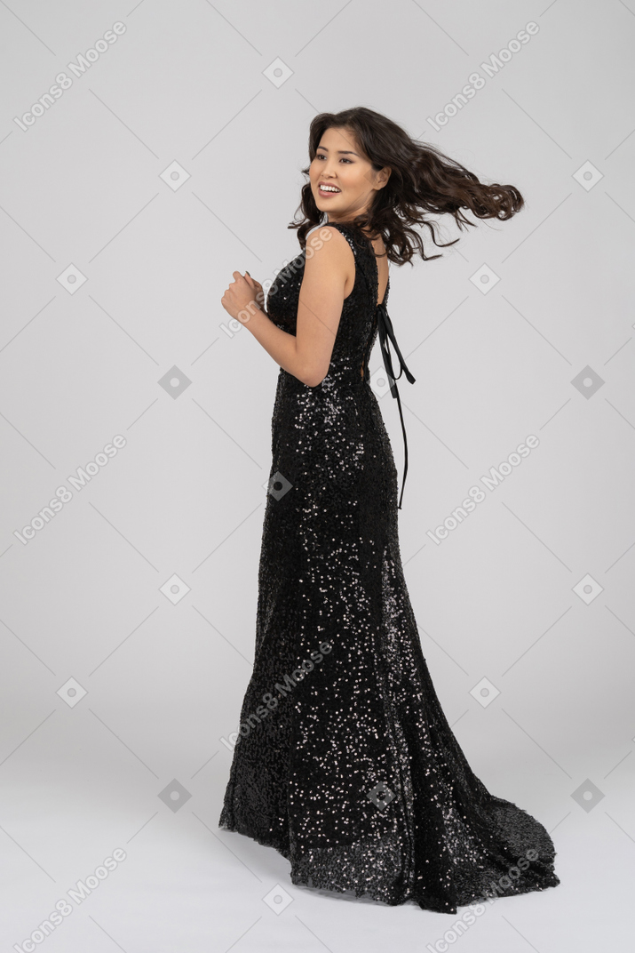 Woman in black evening dress turning around