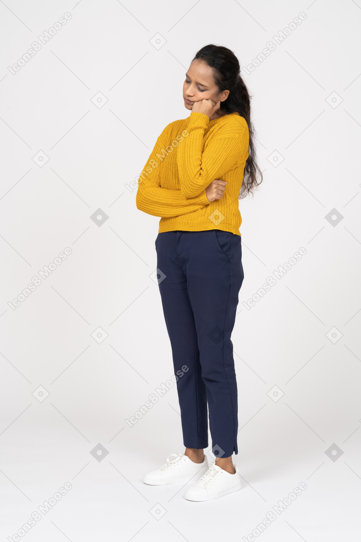Front view of a tired girl in casual clothes holding fist on cheek