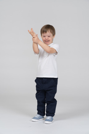 Laughing little boy raising his hand