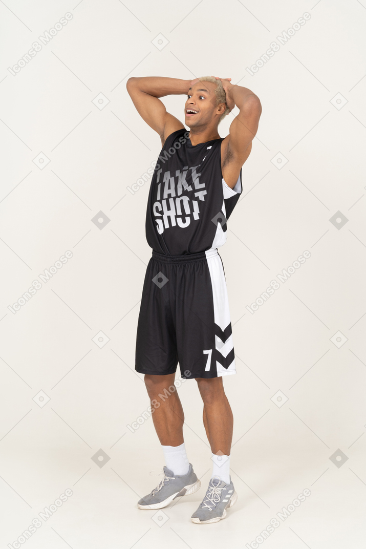 Vista di tre quarti di un giovane giocatore di basket maschio sorpreso