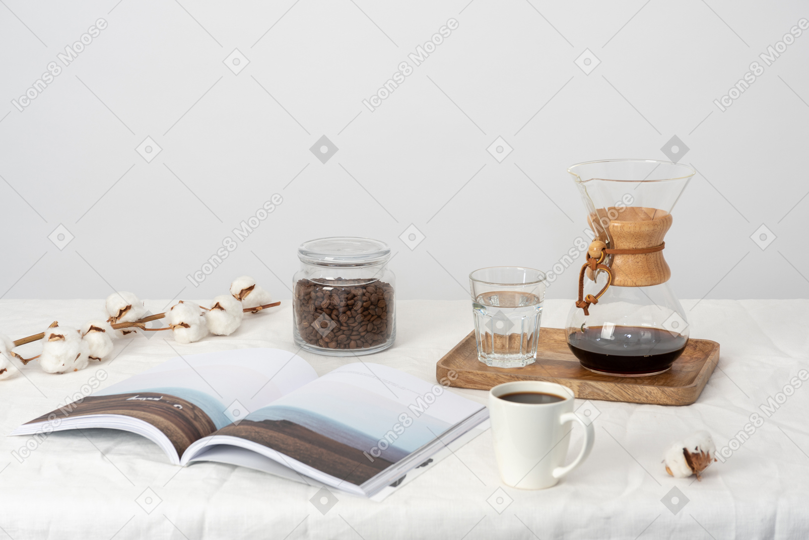 Chemex e copo de água na bandeja, grande copo de água, jar com grãos de café, magazibe e ramo de algodão