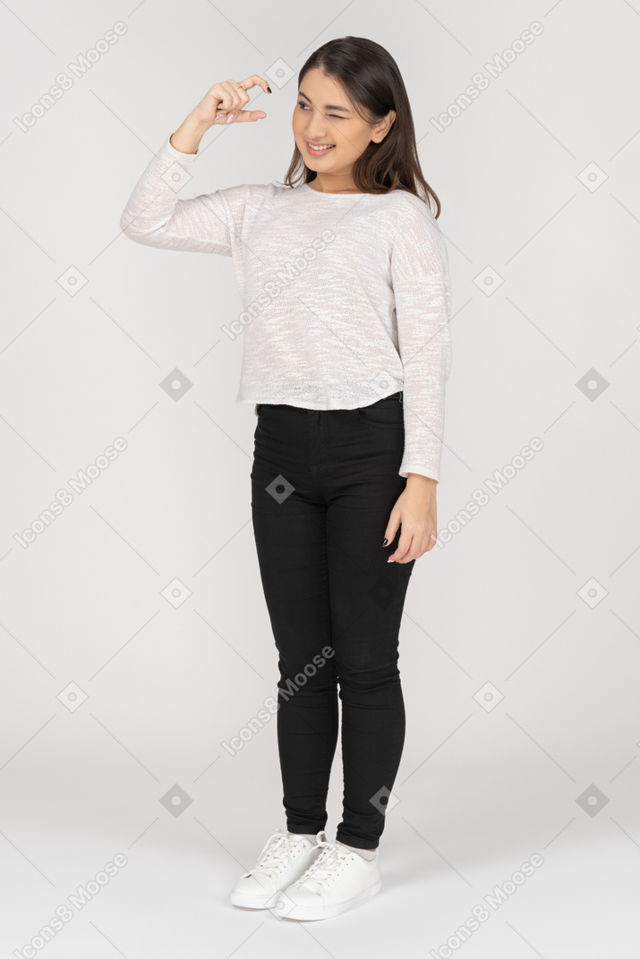 Three-quarter view of a young indian female wearing casual clothes showing size of something small