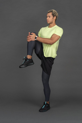 Athlete stretching his leg