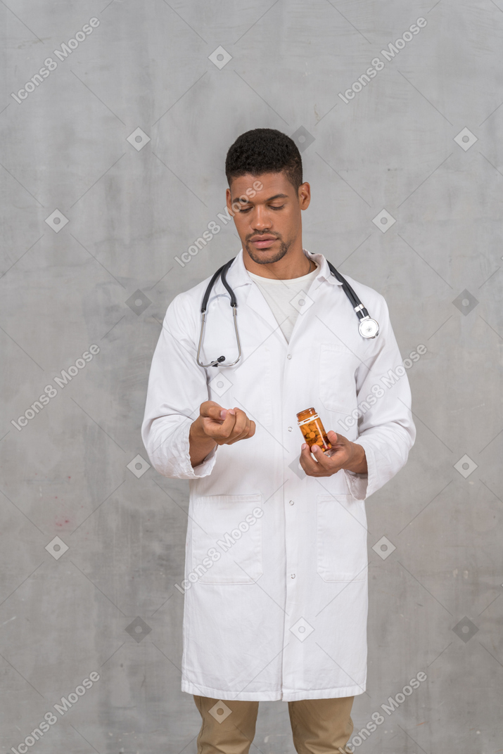 Врач-мужчина смотрит на таблетки