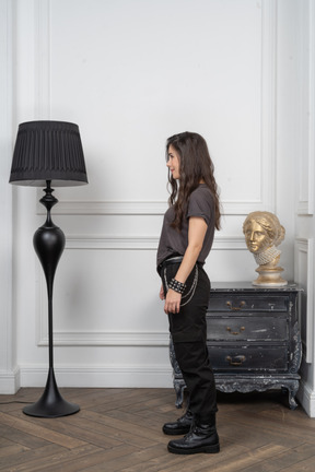 Side view of a young female rocker standing in a room