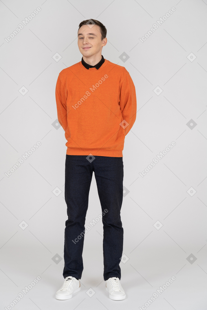 Junger mann im orangefarbenen sweatshirt stehend