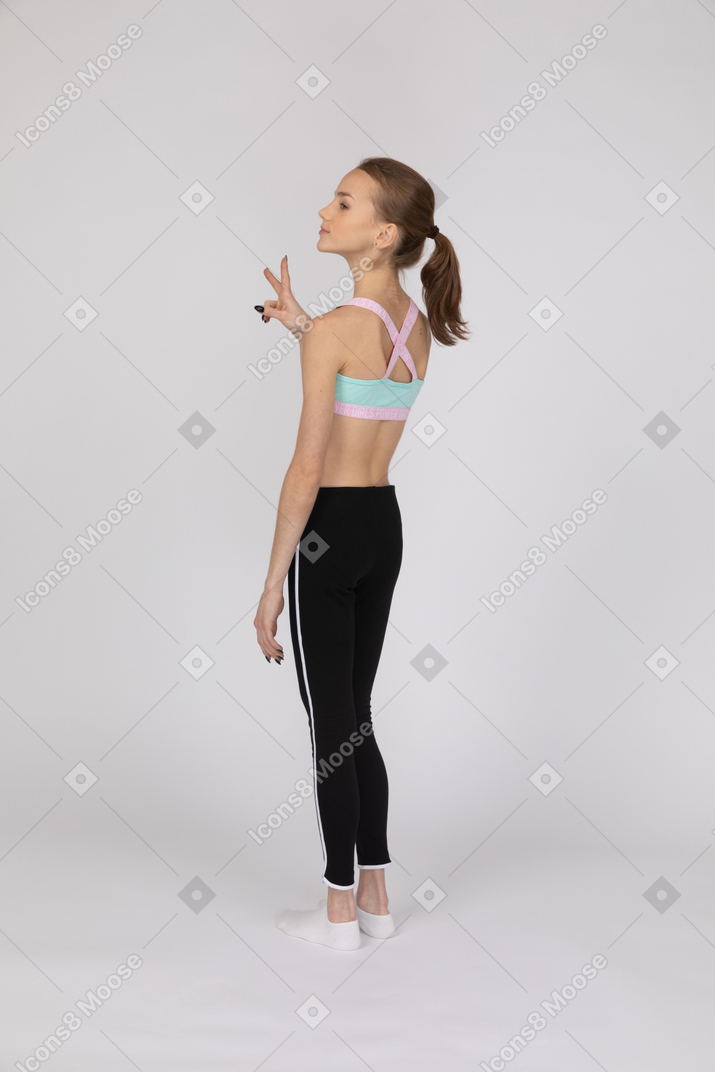 Side view of teen girl showing peace sign