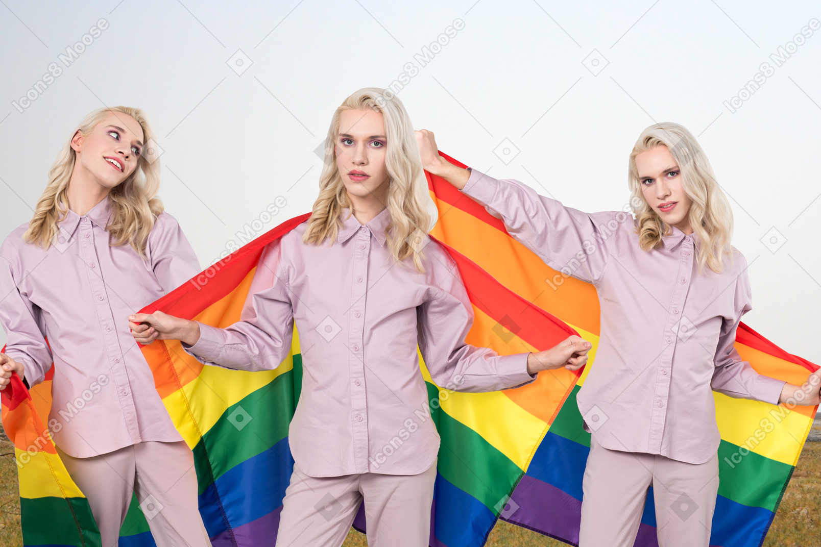 Non binary person standing with lgbtq flag