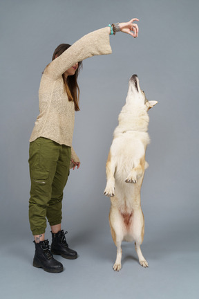 A figura intera di una dottoressa che allena il suo cane