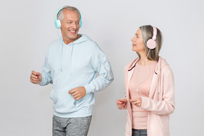Paar mittleren alters joggen während sie musik hören