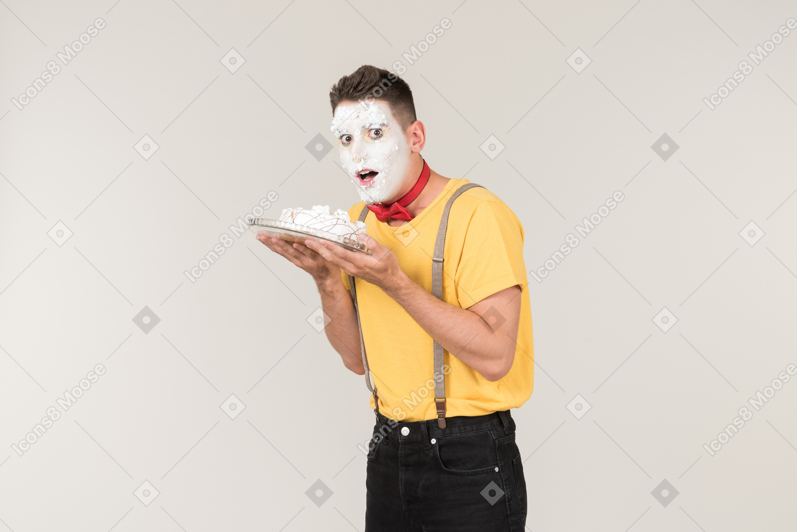 케이크를 들고 그의 얼굴에 케이크 크림과 함께 남성 광대