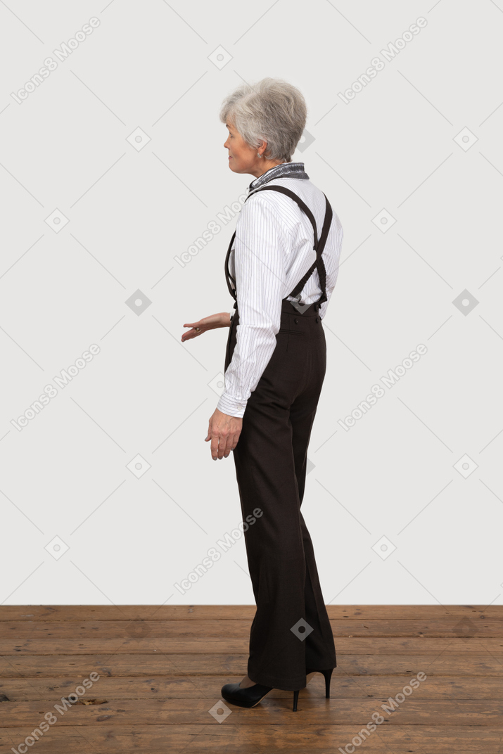 Вид сбоку на старуху в офисной одежде, протягивающую руку