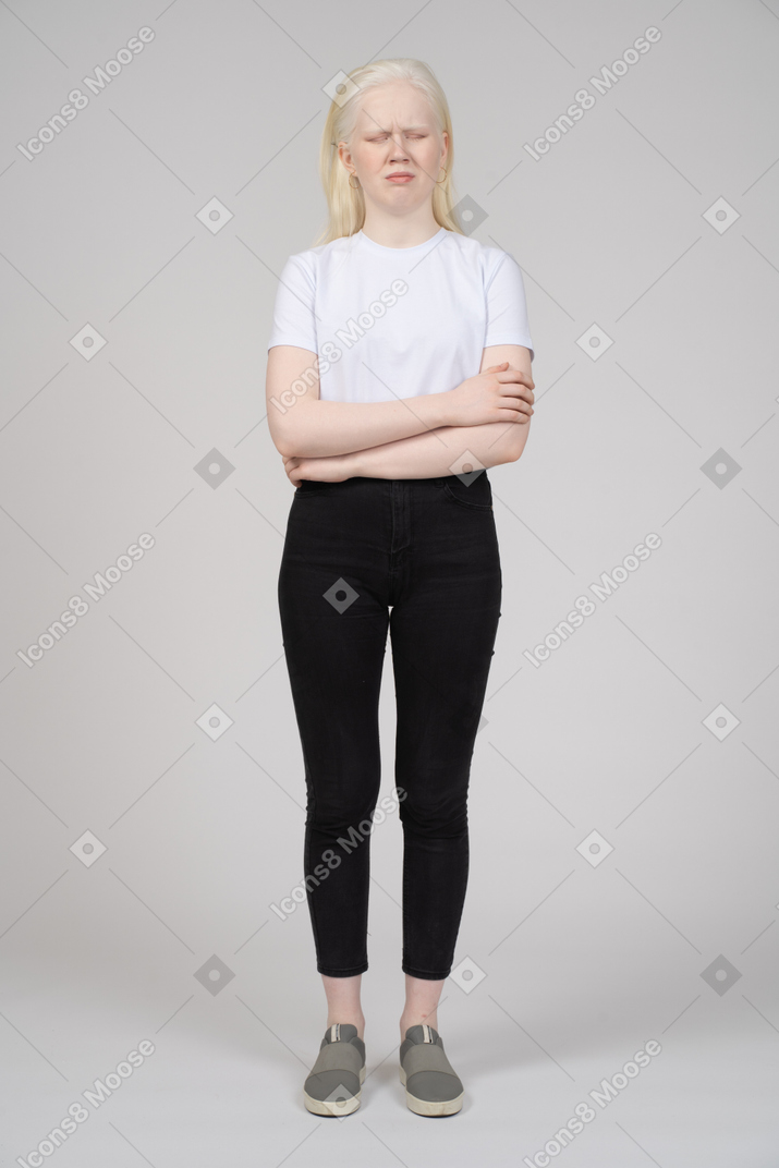 一位站立的年轻女子的正面图，双臂交叉