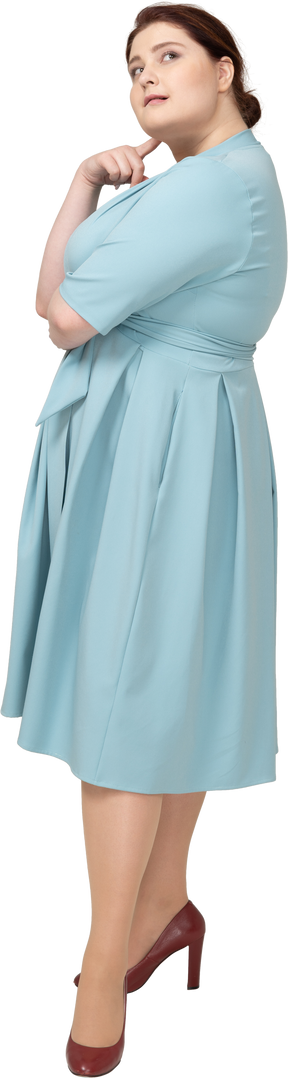 Vista laterale di una donna in abito blu che sogna