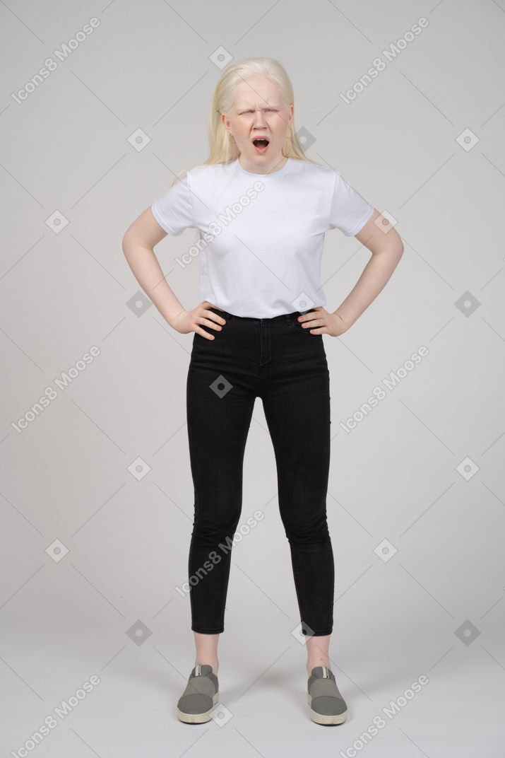 Front view of a yawning girl with hands on her waist