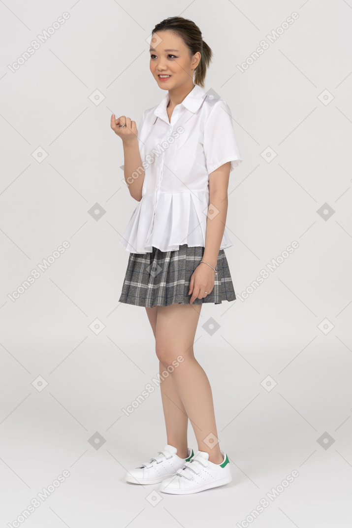Sorrindo menina asiática acenando com um dedo