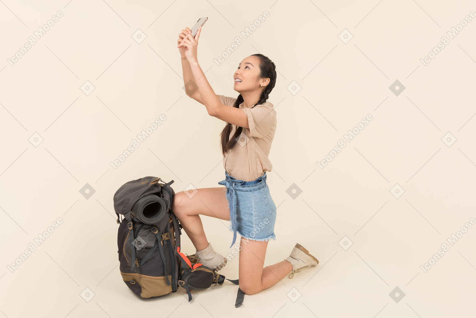 Giovane donna asiatica in piedi vicino allo zaino e scattare foto