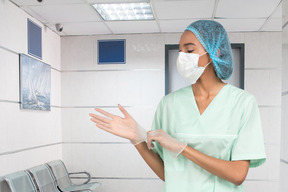A nurse wearing a surgical mask and gloves