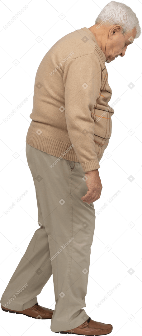 Side view of an old man in casual clothes walking and looking down