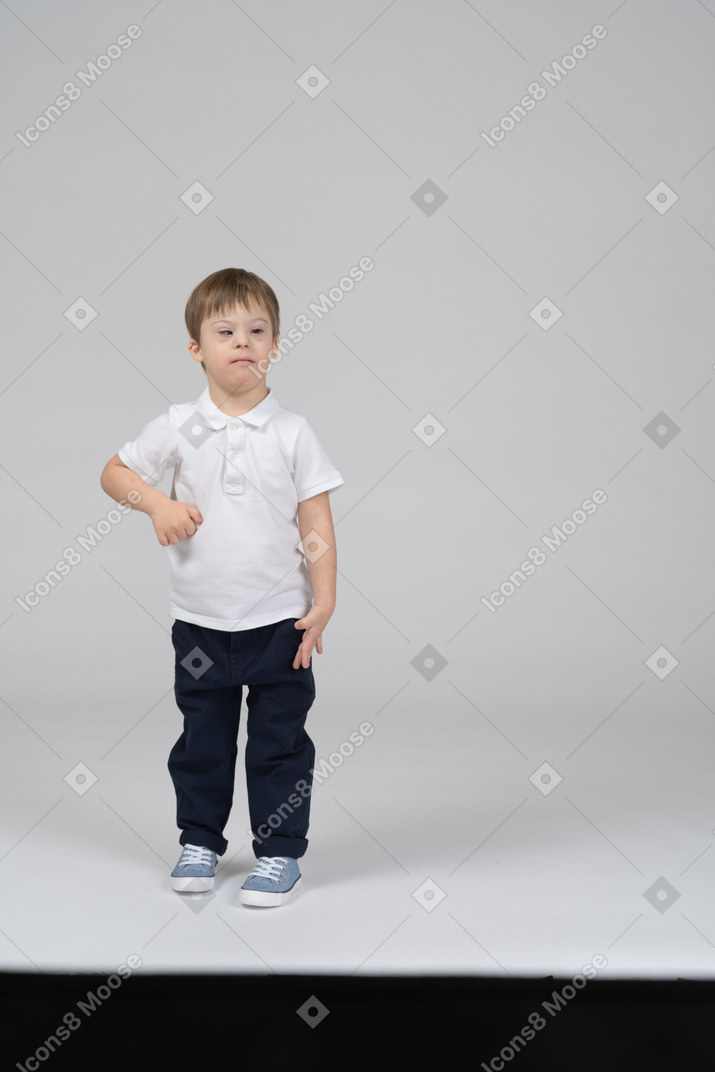 Front view of little kid standing with one arm bent
