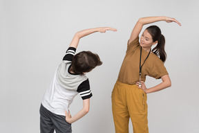 Pe female teacher and pupil stretching