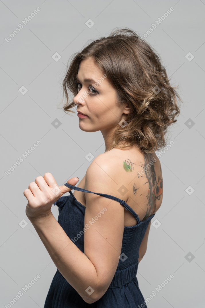 Woman with tattooed back undressing