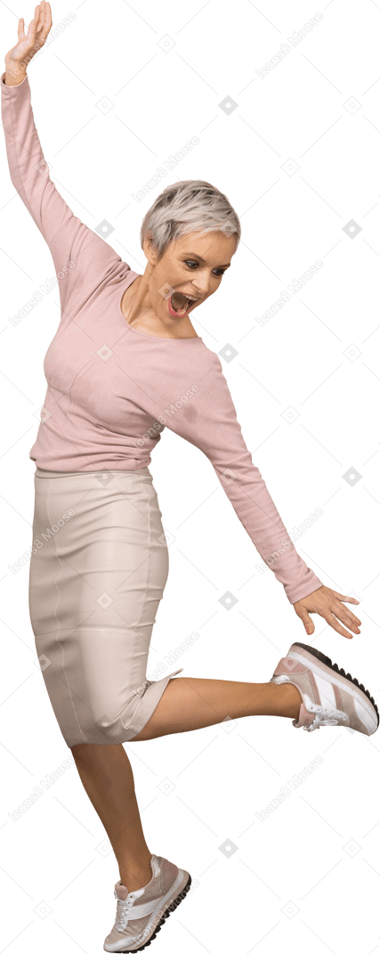 Front view of a happy woman in casual clothes jumping