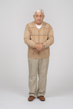 Front view of an old man in casual clothes standing still