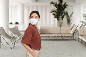 A woman wearing a face mask in a living room