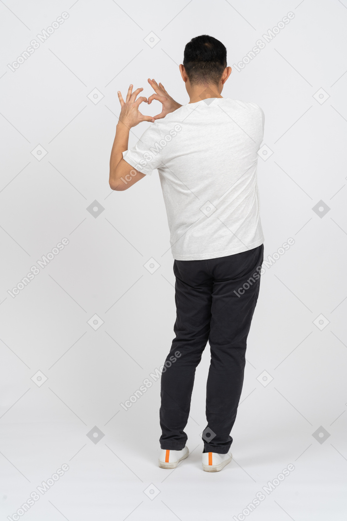 Back view of a man in casual clothes making heart with fingers