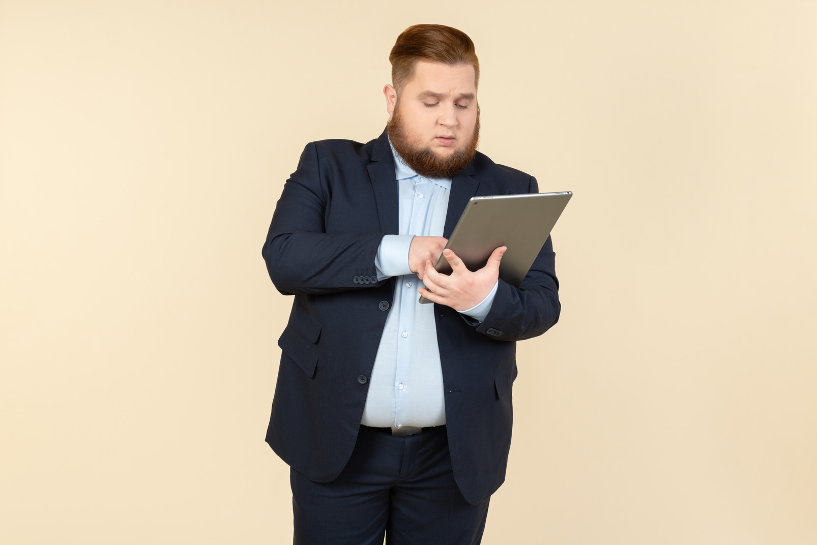 Pensive young overweight office worker holding digital tablet