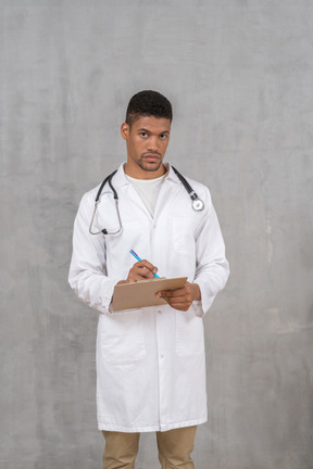Young male doctor taking medical records