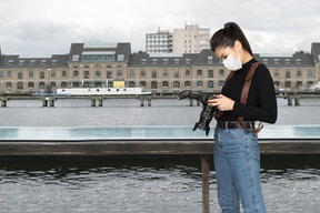 A woman wearing a face mask and holding a camera