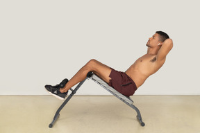 Side view of man doing bench ab exercises
