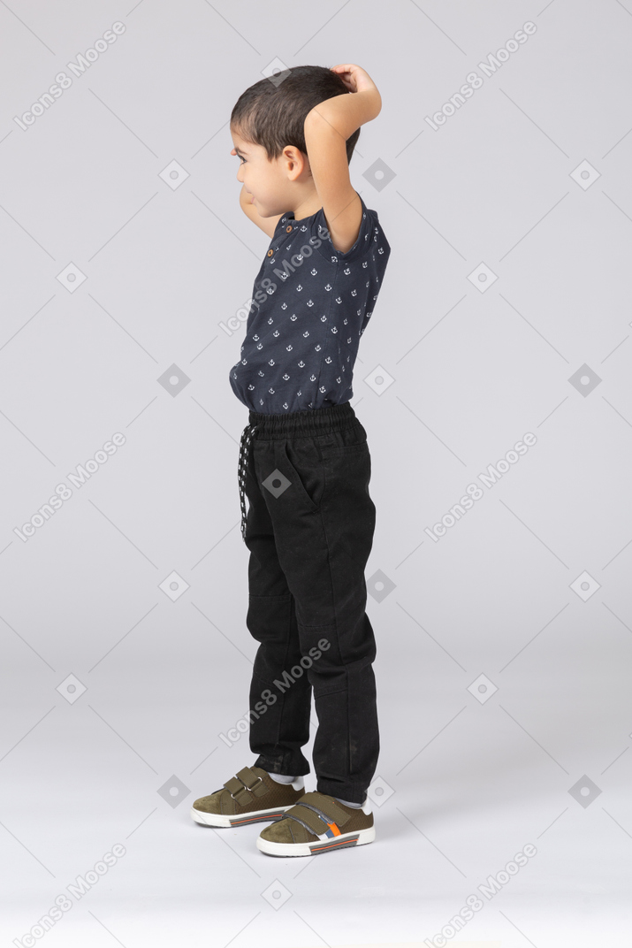 Side view of a cute boy posing with hands behing head