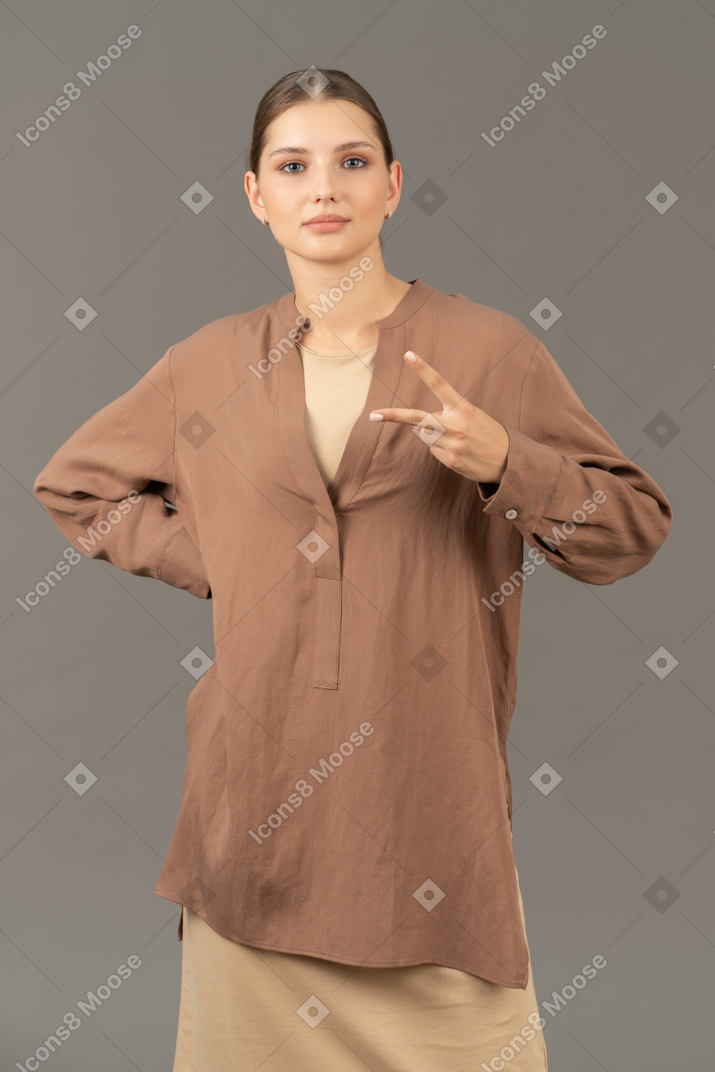 Young woman flashing peace hand sign