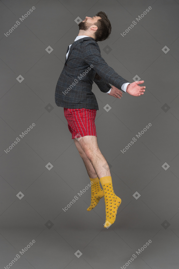 Bearded brunette man levitating in profile